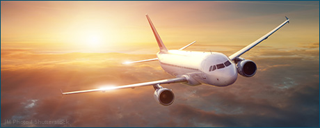 photo of commercial airplane flying above clouds