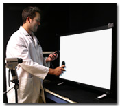 Photo of technician taking a brightness reading from an LCD